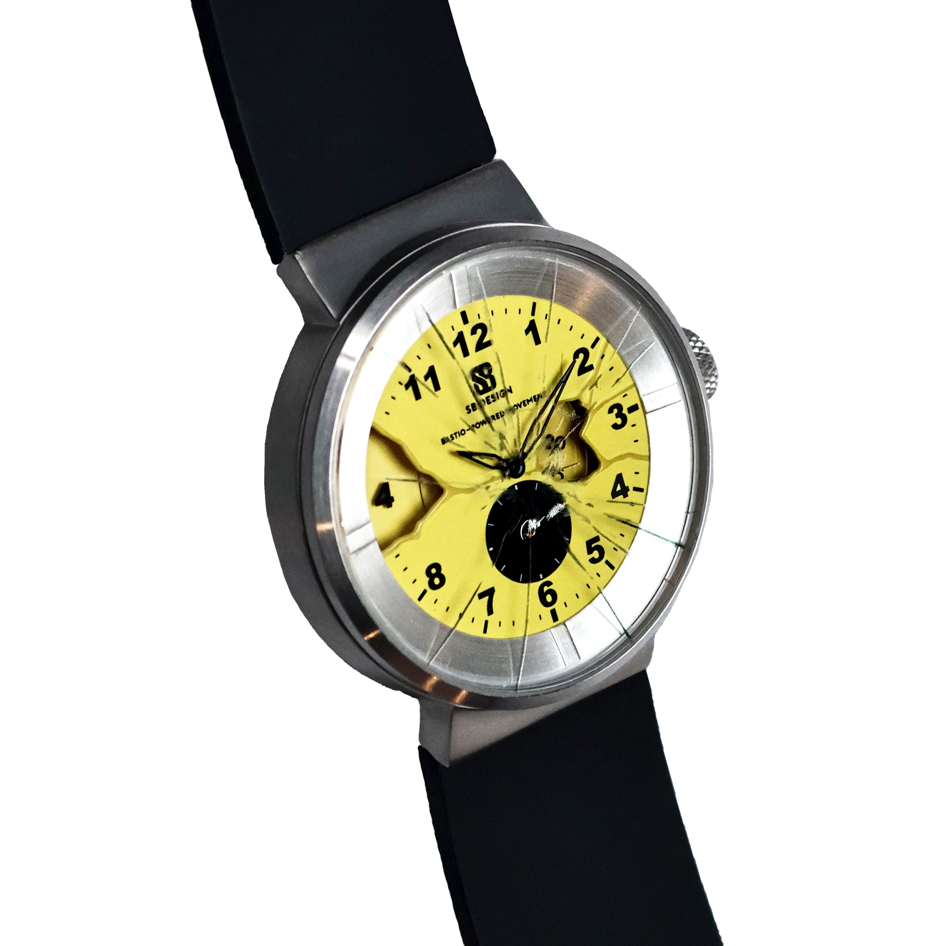 Wristwatch with yellow dial and black numbers glass painted to look as if it is cracked and black silicone strap and a stainless steel case on a white background Broken Time Watch Brad Podray Mad Hudson