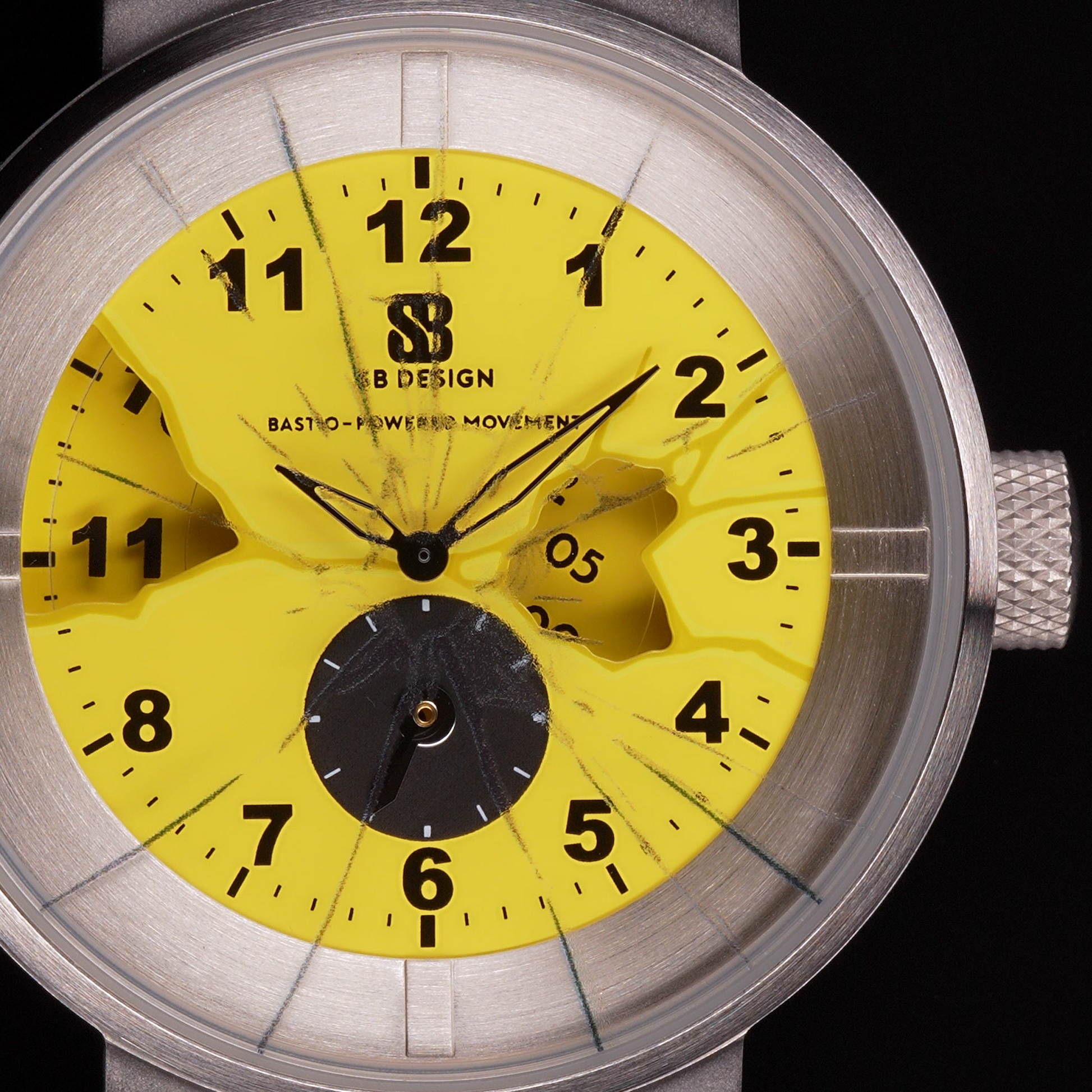Wristwatch with yellow dial  and black numbers glass painted to look as if it is cracked and black silicone strap and a stainless steel case on a black background Broken Time Watch Brad Podray Mad Hudson