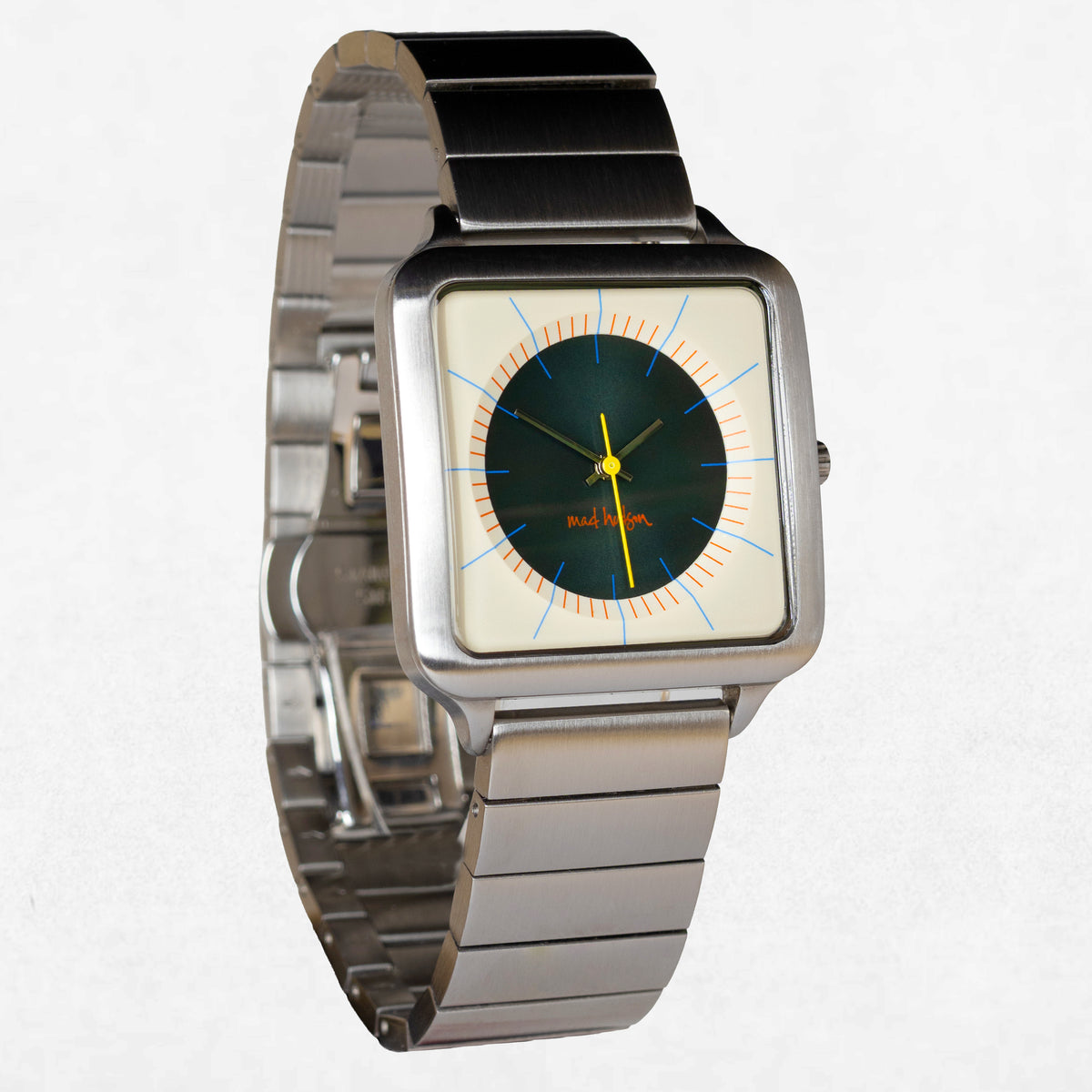 A square analog watch with a brushed silver metal link bracelet, a cream-colored dial, and a dark green center. The watch features light blue hour markers and yellow hands, with the brand name 'RADIANT' printed in red on the dial.