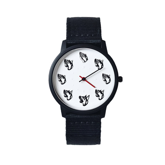 Wristwatch with a black and white face dog head and praying hands with a black stainless steel case and black nylon strap red hour hand on a white background Dogma Watch Bryce Wong Mad Hudson