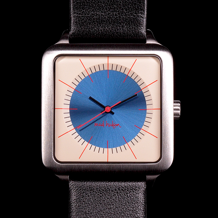 Eddie Wristwatch with stainless steel case and black leather strap, tan and blue face against a black background mad hudson watches