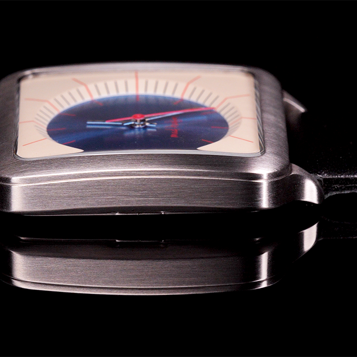 Eddie Wristwatch with stainless steel case and black leather strap, tan and blue face against a black background mad hudson watches