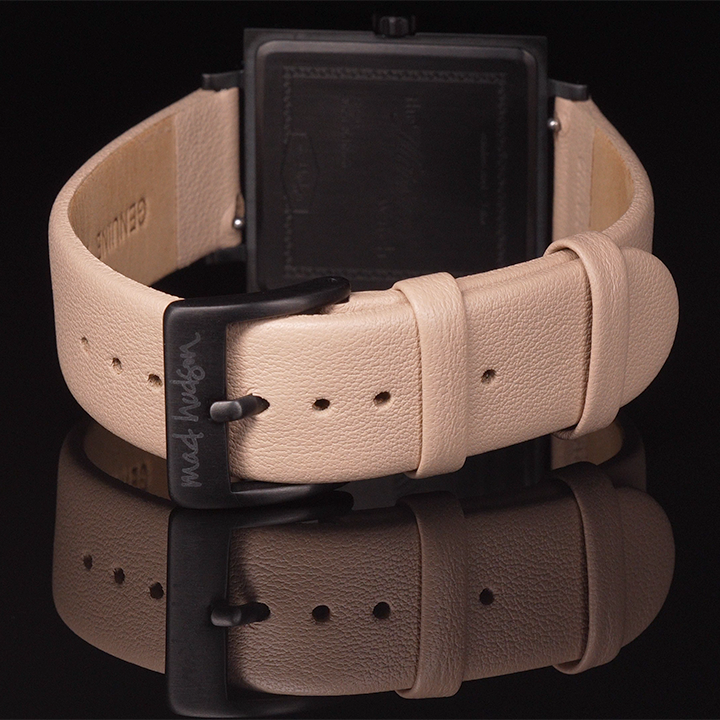 back of Marshall watch Beige leather belt with black buckle on a reflective surface against a black background Mad hudson watches