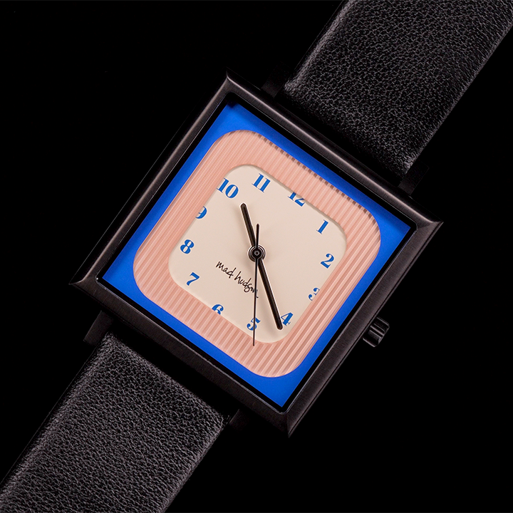 Wristwatch with a black leather strap and square case pink blue and tan face steel and black hands blue numbers on a black background The Miami Watch Mad Hudson Watches